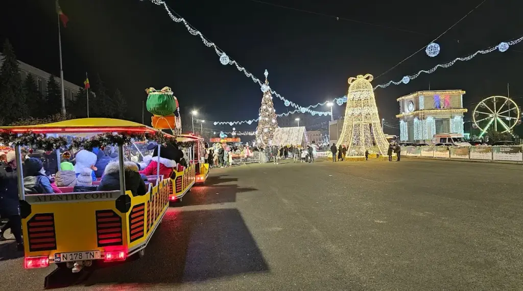 Great National Assembly Square in Chișinău in the evening, with festive lights and a tourist train